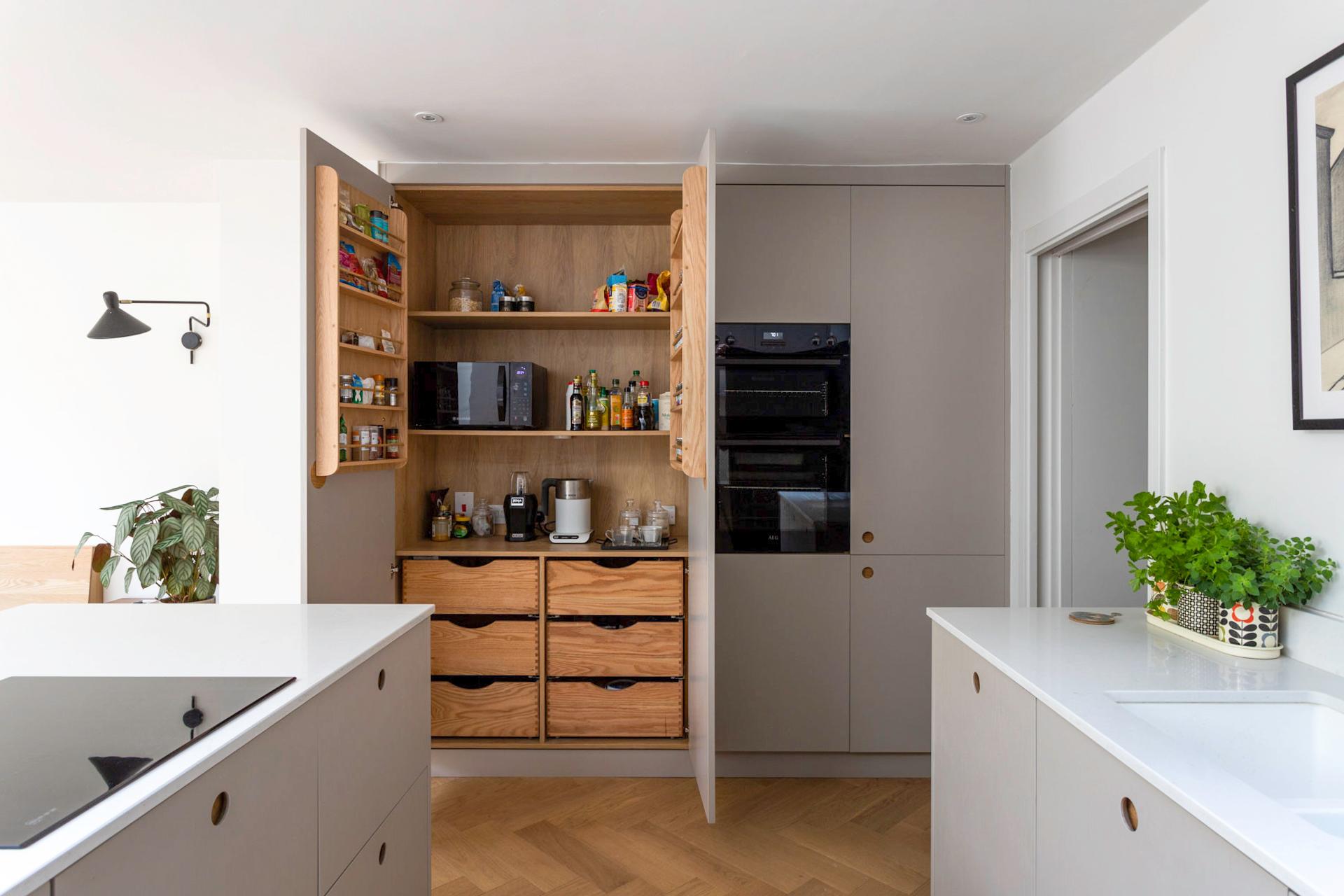 A captivating view of the Camberwell kitchen, featuring soft dove grey cabinetry and delicate Ladbroke handles, exuding a contemporary and elegant aesthetic.