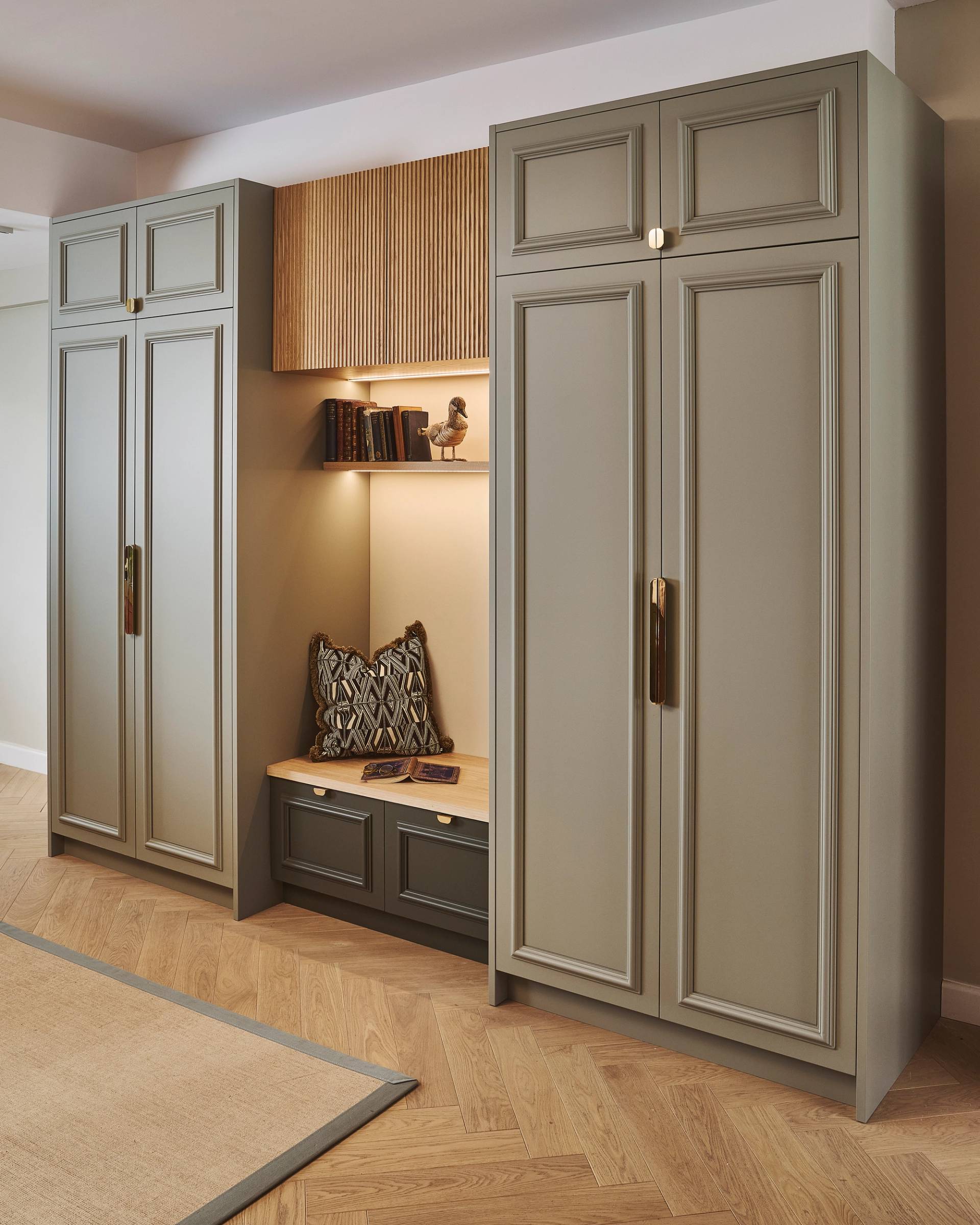 A kitchen with blue cabinets, marble countertops, and a farmhouse sink. Wooden shelves hold dishes, plants, and decorative items. A tall cabinet displays more dishes. A backsplash with a black and white pattern complements the design.
