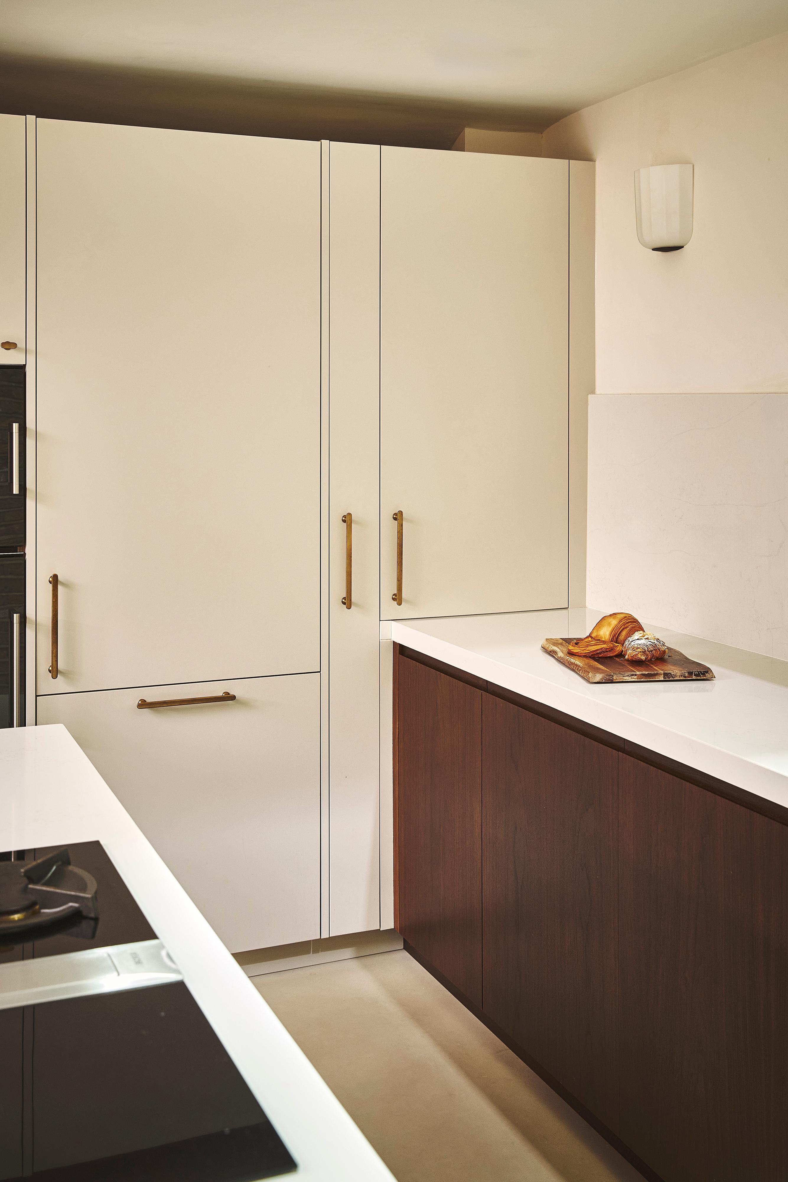 Modern kitchen with open white cabinets, gold handles