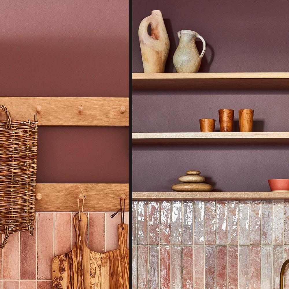 A kitchen scene with wooden shelves and pegs, ceramic vases, small wooden cups, woven basket, cutting boards, and glossy pink tiles against a mauve and pink wall.