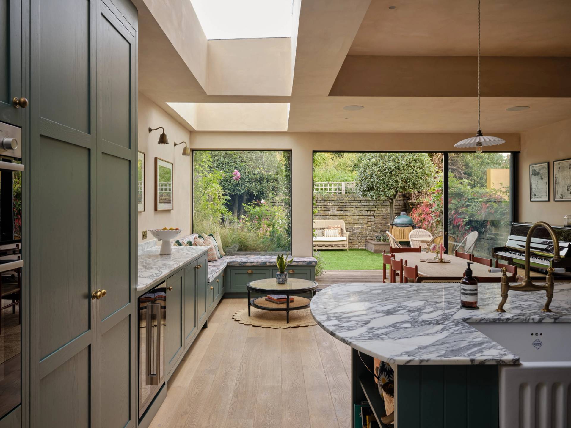 A wooden cabinet with glass doors displaying ceramic dishes, bowls, and a jug. Below is a light blue drawer set with a marbled countertop. Warm lighting highlights the textures and tones of the ceramics and wood