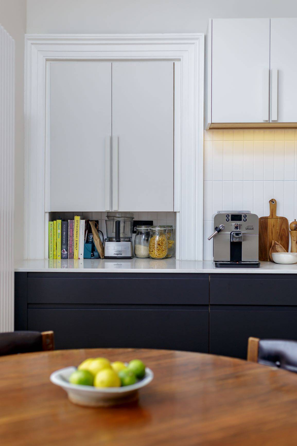 Detailed view of the bespoke mantelpiece adorning the kitchen wall. The intricate carvings and polished finish add a touch of elegance to the space, complementing the overall design aesthetic.