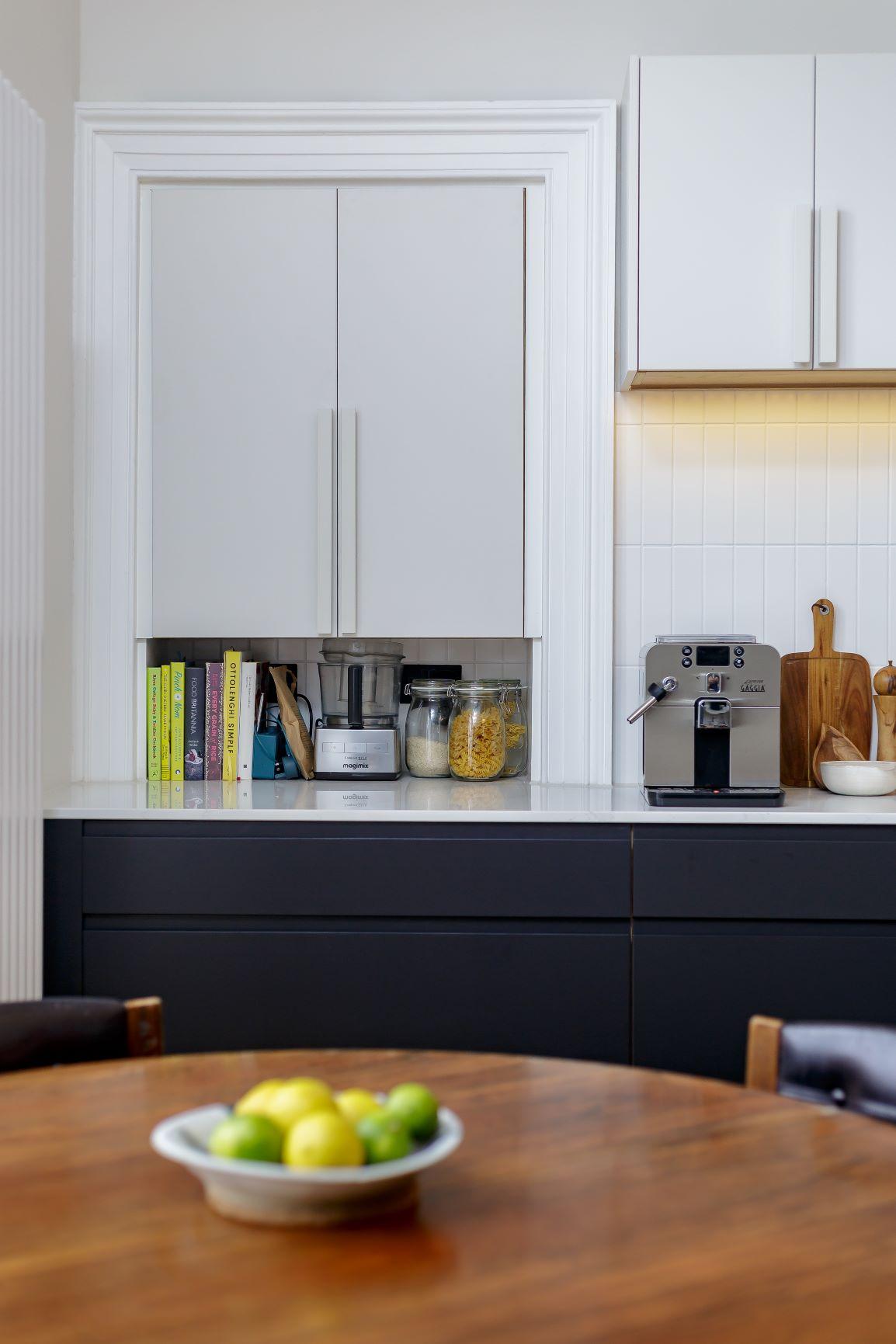 Detailed view of the bespoke mantelpiece adorning the kitchen wall. The intricate carvings and polished finish add a touch of elegance to the space, complementing the overall design aesthetic.
