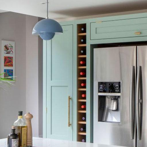 Modern kitchen with pastel blue cabinets, a built-in stainless steel refrigerator with a water dispenser, a vertical wine rack, a blue pendant light, and colorful artwork on the wall.
