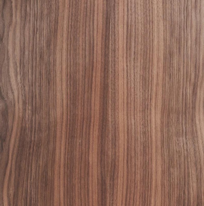 Wooden surface with a smooth, natural grain pattern. The wood's colour varies from light to dark brown, with vertical, wavy lines creating an organic texture. The surface appears polished and consistent across the image.
