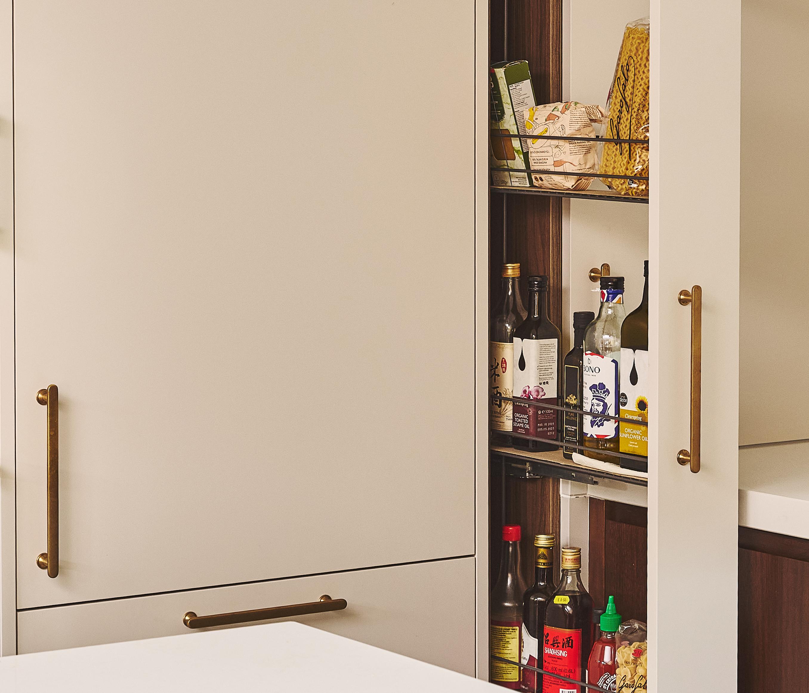 Close-up of a wooden cabinet with round cutout handles and a white marble countertop, set against a blurred dark background.