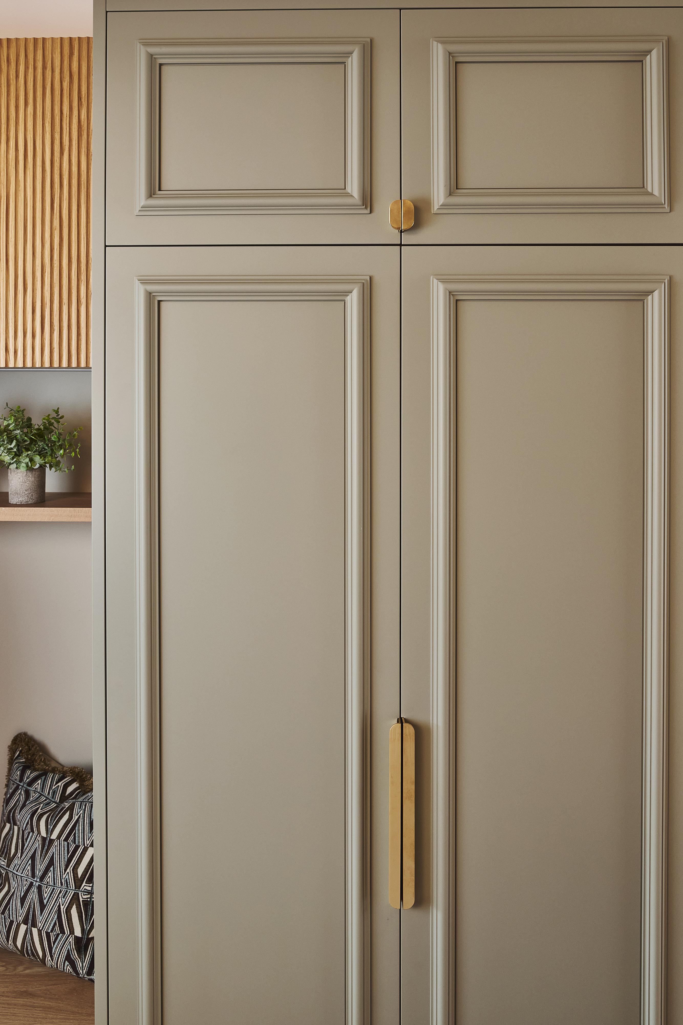 A close-up of a wardrobe painted in Burnham Green and open door