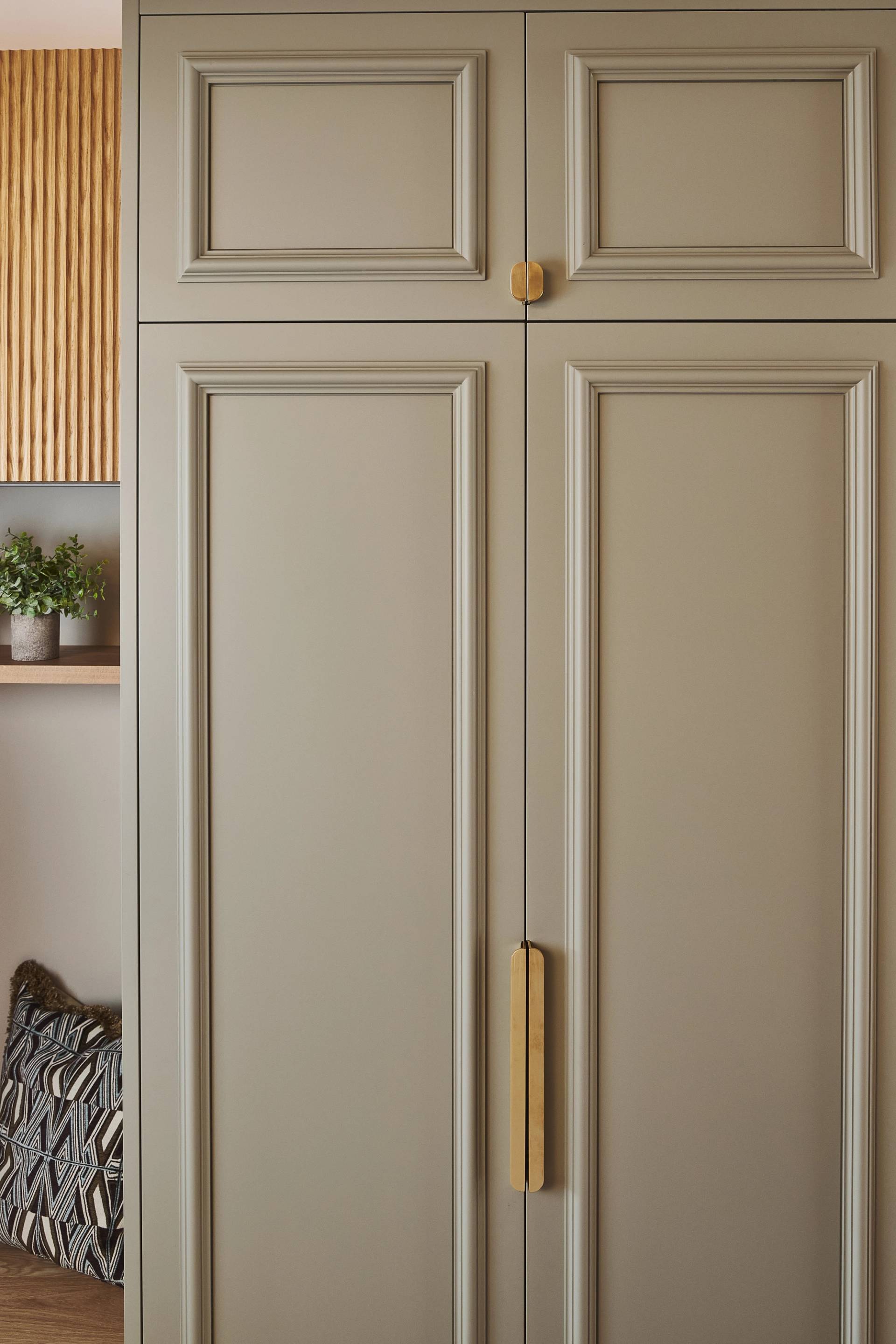 A close-up of a wardrobe painted in Burnham Green and open door