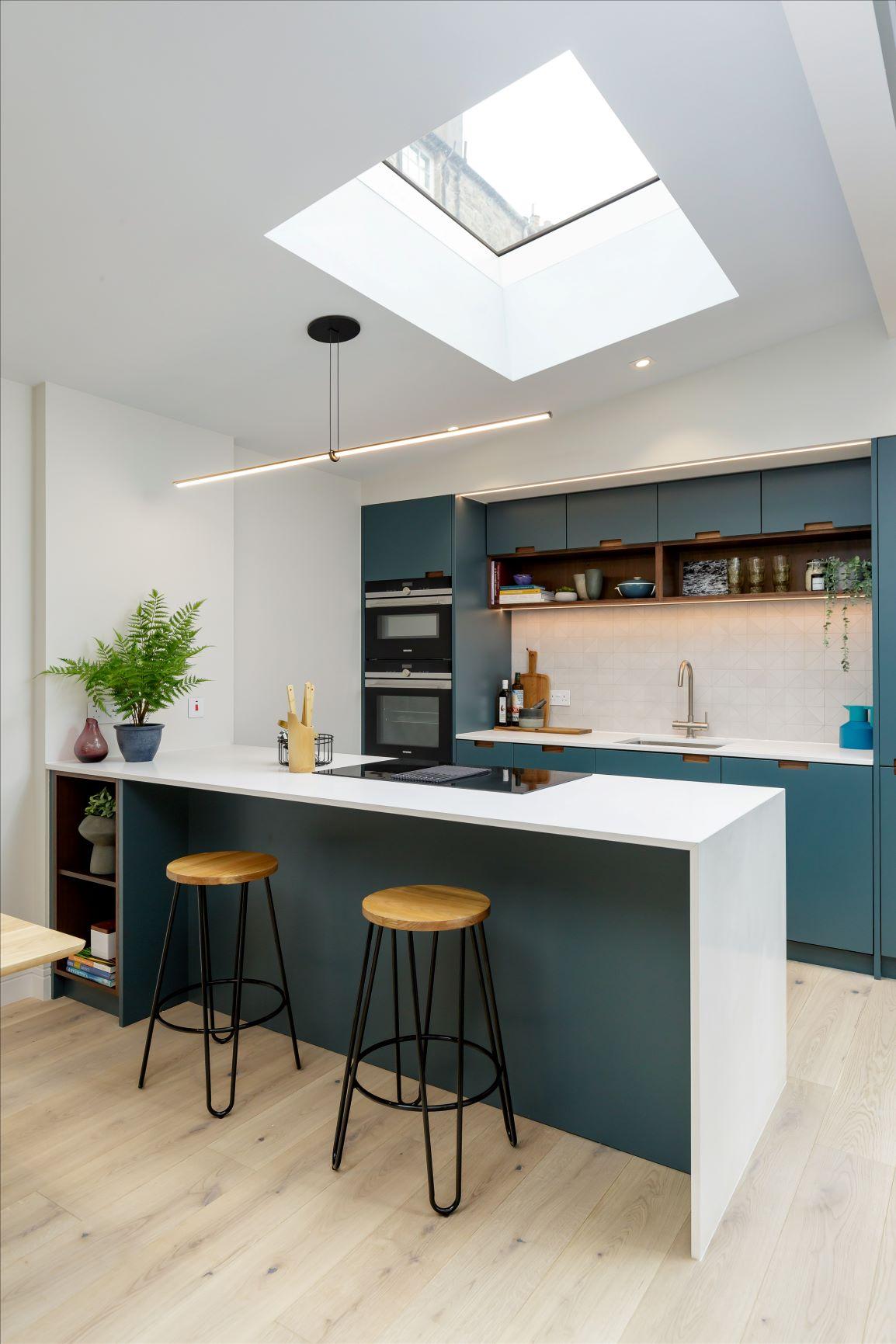 Step into a culinary haven, where walnut cabinetry and deep blue paintwork create an enchanting ambiance. The continuous white quartz countertop adds a touch of elegance, while the eye-catching tiled splashback exudes sophistication.