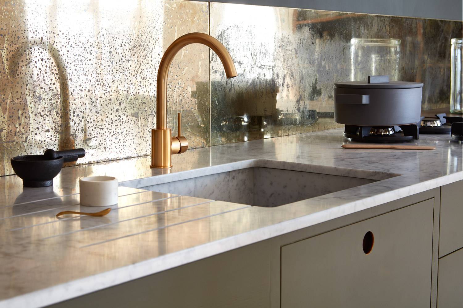 A compact yet highly functional Ladbroke kitchen featuring a striking waterfall island. The island's continuous white quartz countertop flows seamlessly into the cabinets, creating a sense of openness and fluidity.