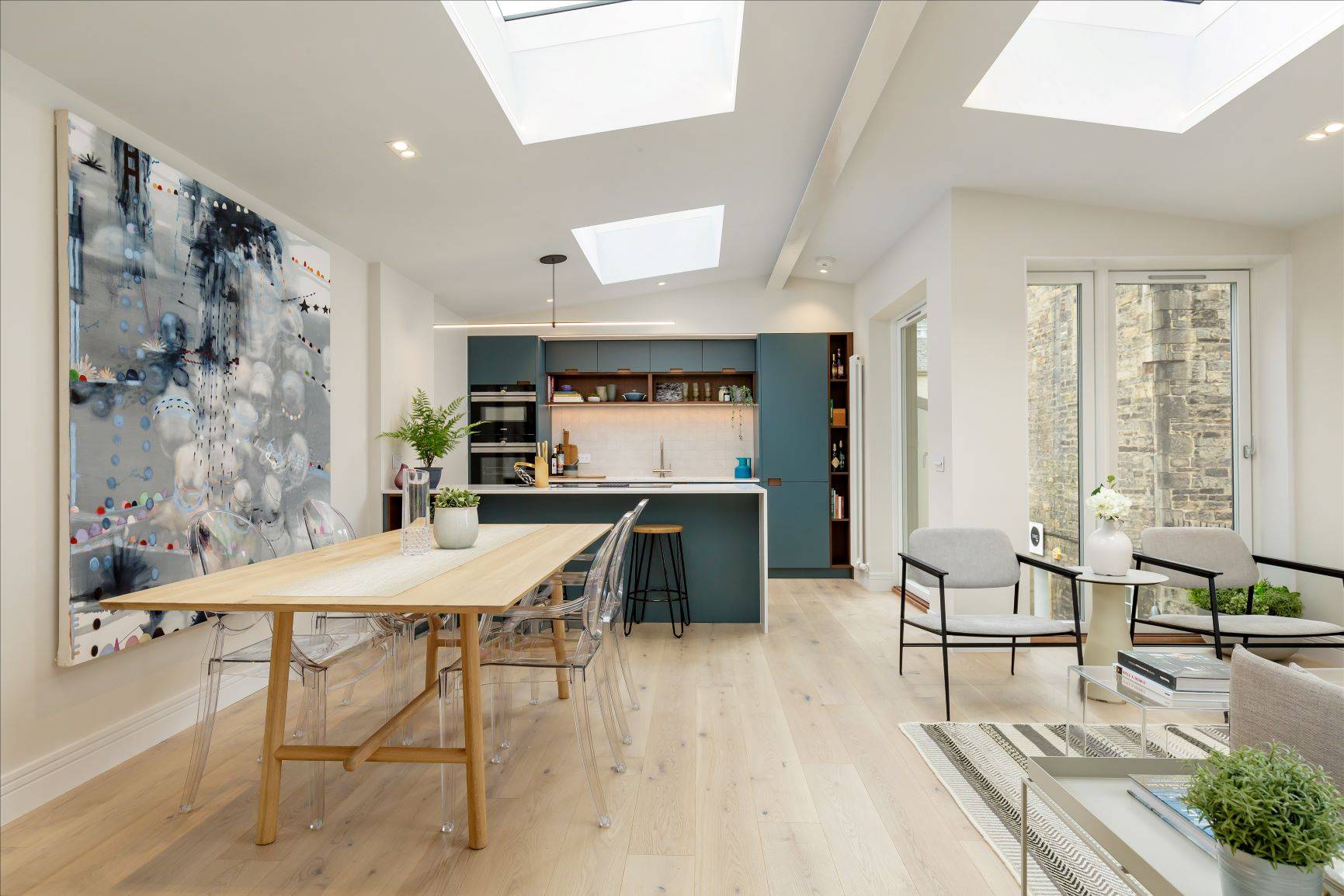 The Castle Mews kitchen features a peninsula island, providing an additional worktop, storage and seating area. The island's continuous quartz countertop flows seamlessly into the cabinets, creating a sense of openness and fluidity