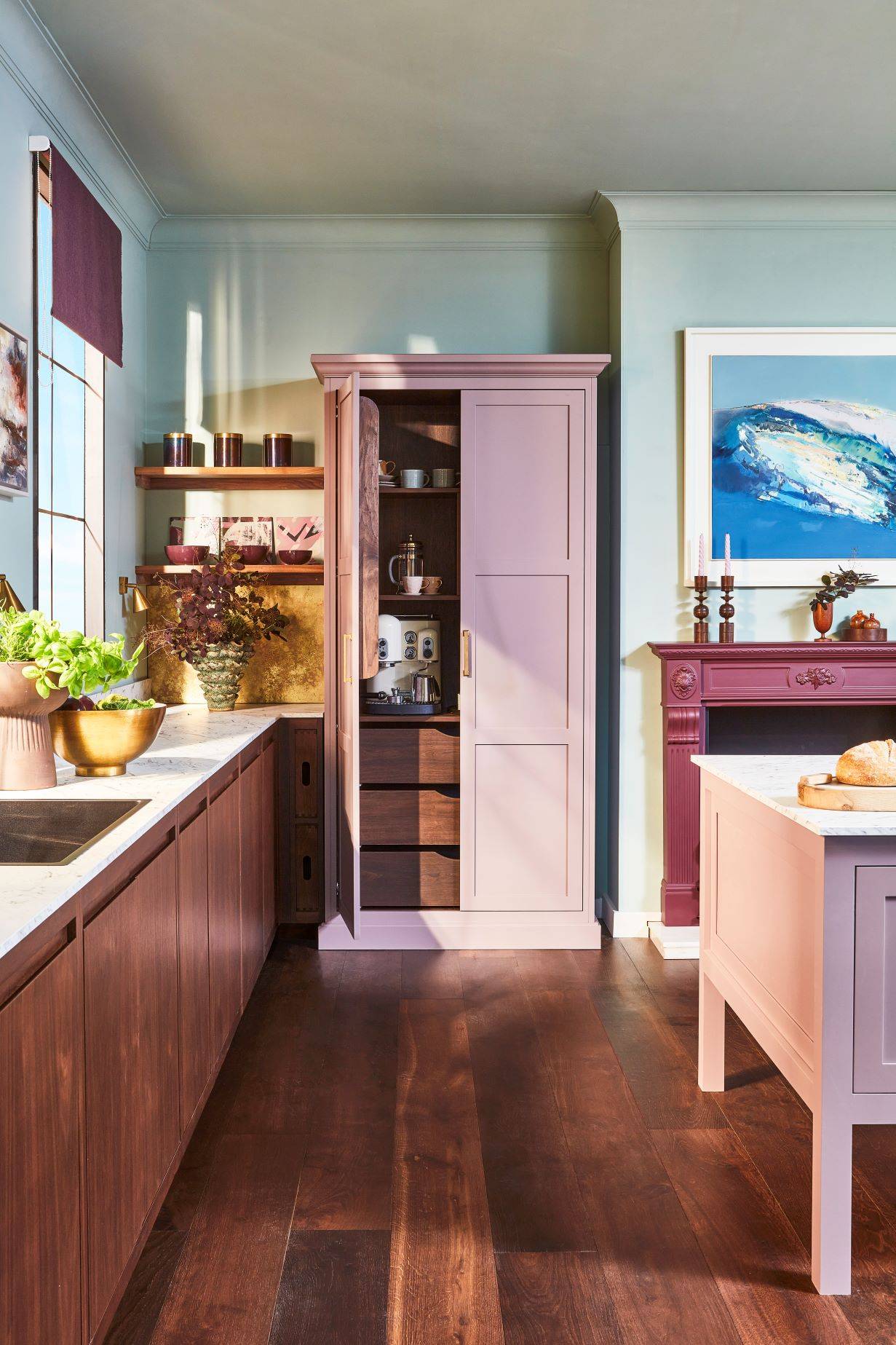 Become the centre of attention at this breathtaking drinks cabinet, where the harmony of walnut, rich purple hues, and aged brass creates an atmosphere of sophistication and elegance. The kitchen's ample space provides ample seating for enjoying drinks and conversation, while the integrated wine rack adds a touch of refined luxury.