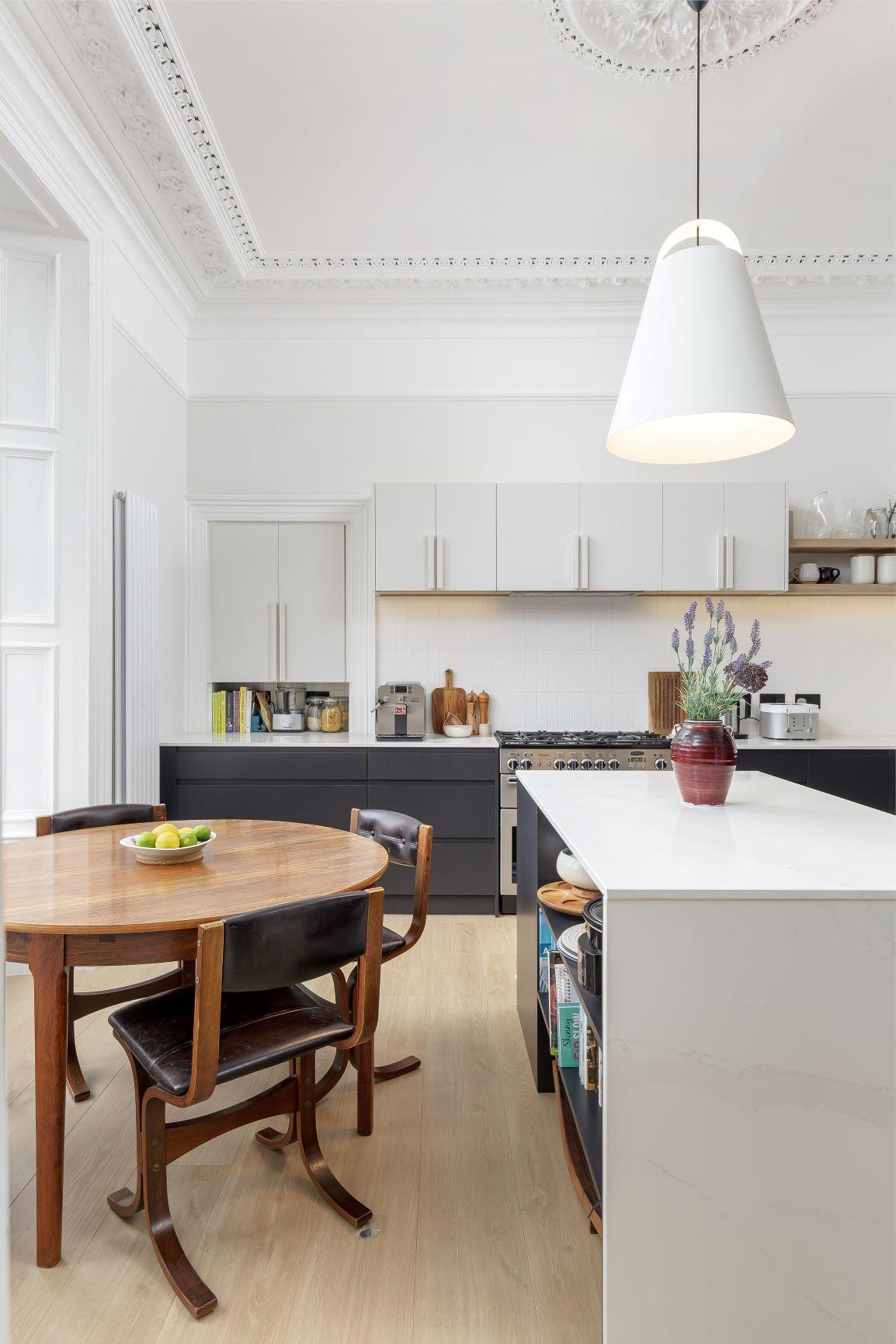 Detailed view of the bespoke mantelpiece adorning the kitchen wall. The intricate carvings and polished finish add a touch of elegance to the space, complementing the overall design aesthetic..