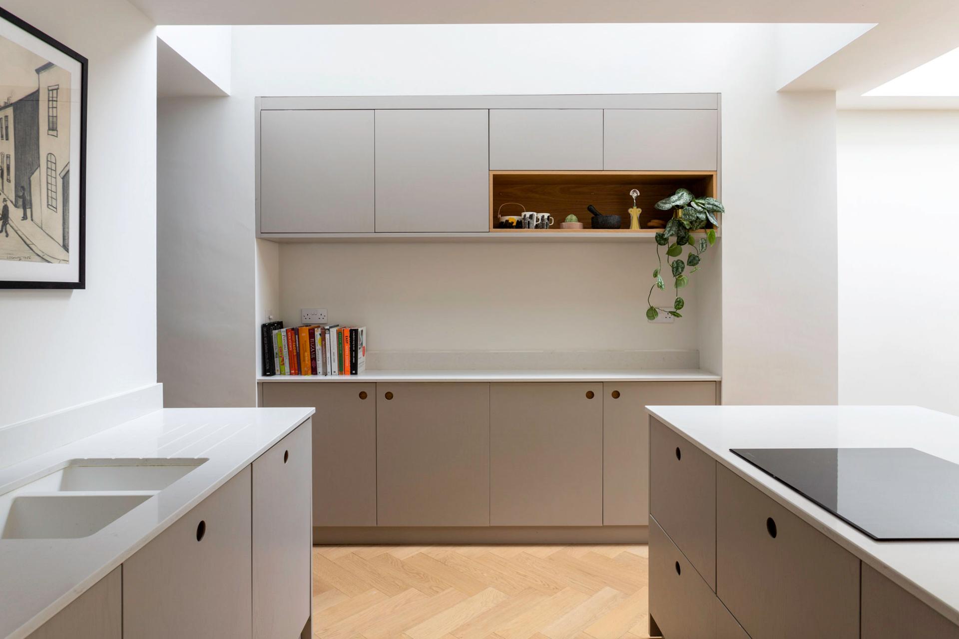 A spacious and functional Camberwell kitchen with ample storage solutions, including a tall larder with Norfolk bar handles, generous cabinets, and a large island with plenty of drawer space.