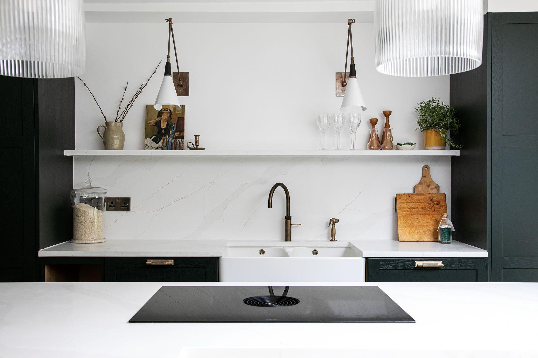 black shaker style kitchen with integrated oven and white worktops and a central island to match