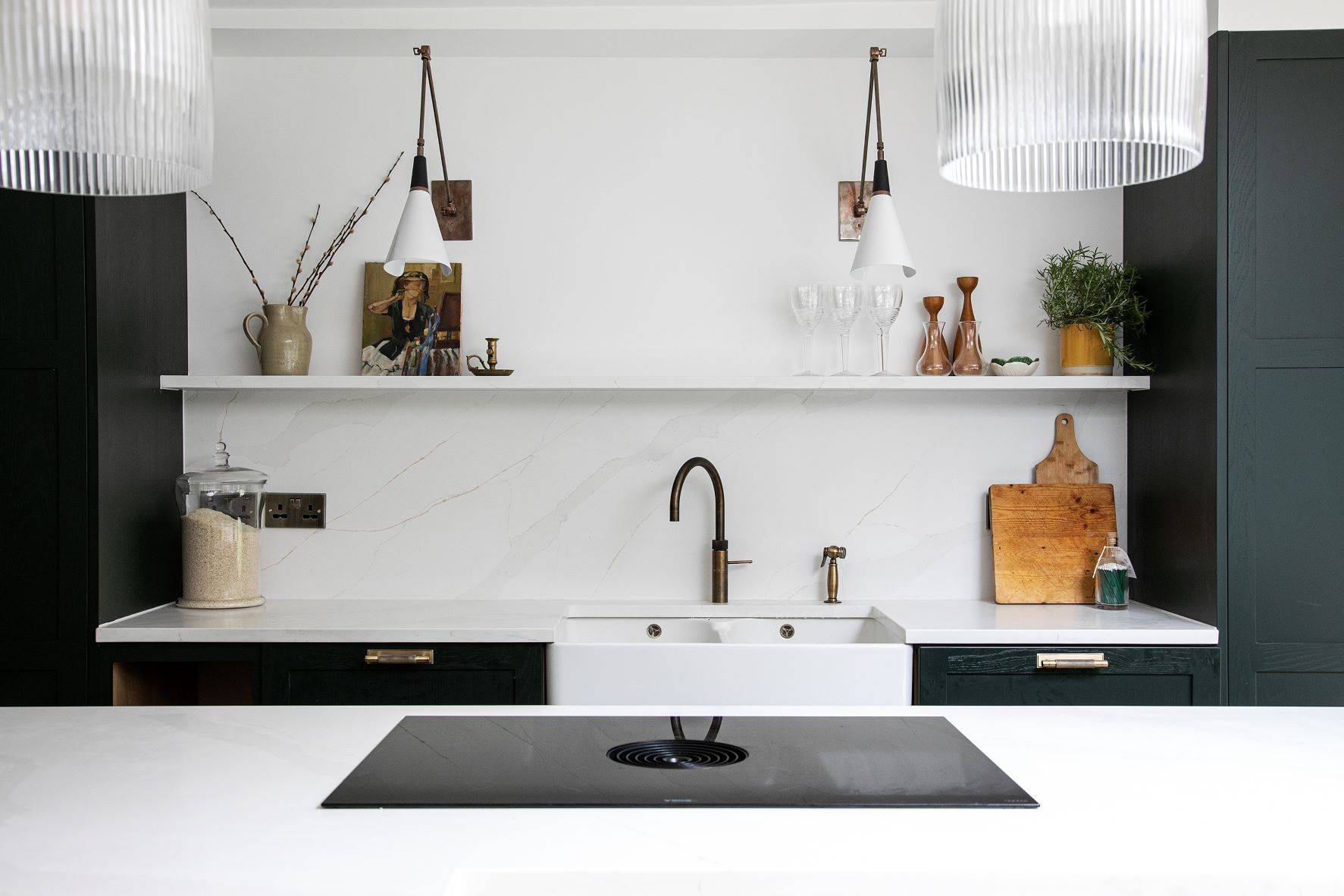 black shaker style kitchen with integrated oven and white worktops and a central island to match