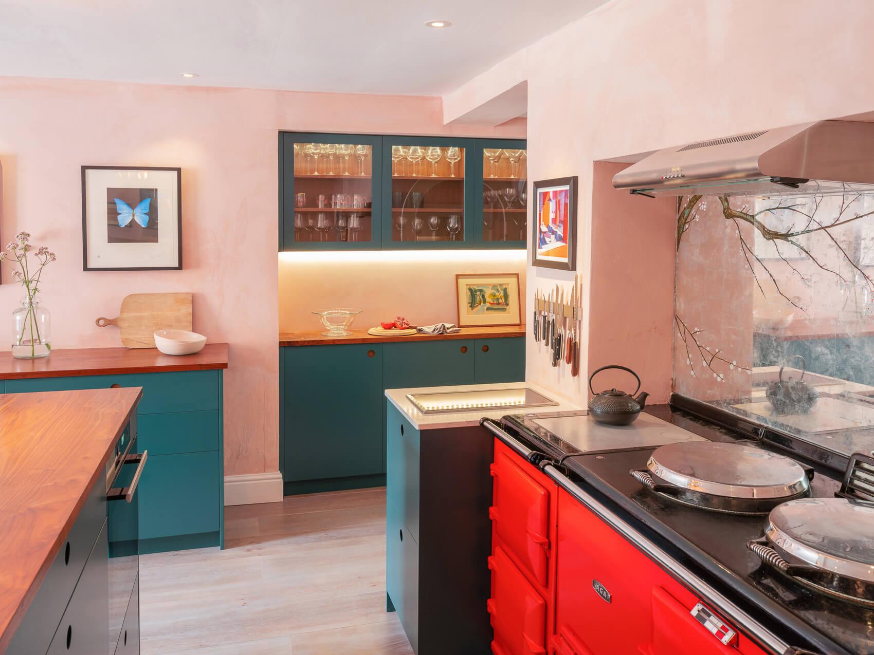 Circular handle details and a bold red Aga set the stage for a sophisticated kitchen masterpiece.
