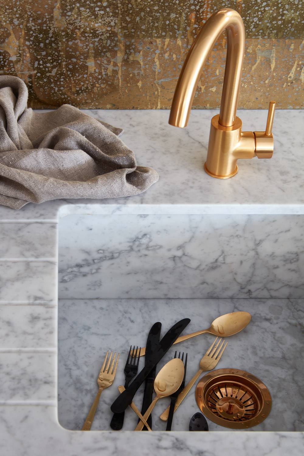 A glimpse into the stylish and inviting Ladbroke kitchen. The continuous marble worktop adds a touch of elegance, while the eye-catching brass splashback and handleless doors exude sophistication.