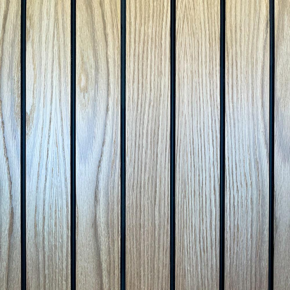Close-up of vertical wooden panels with visible grain patterns, separated by thin dark lines. The wood is light brown and the image shows a repetitive, symmetrical arrangement.