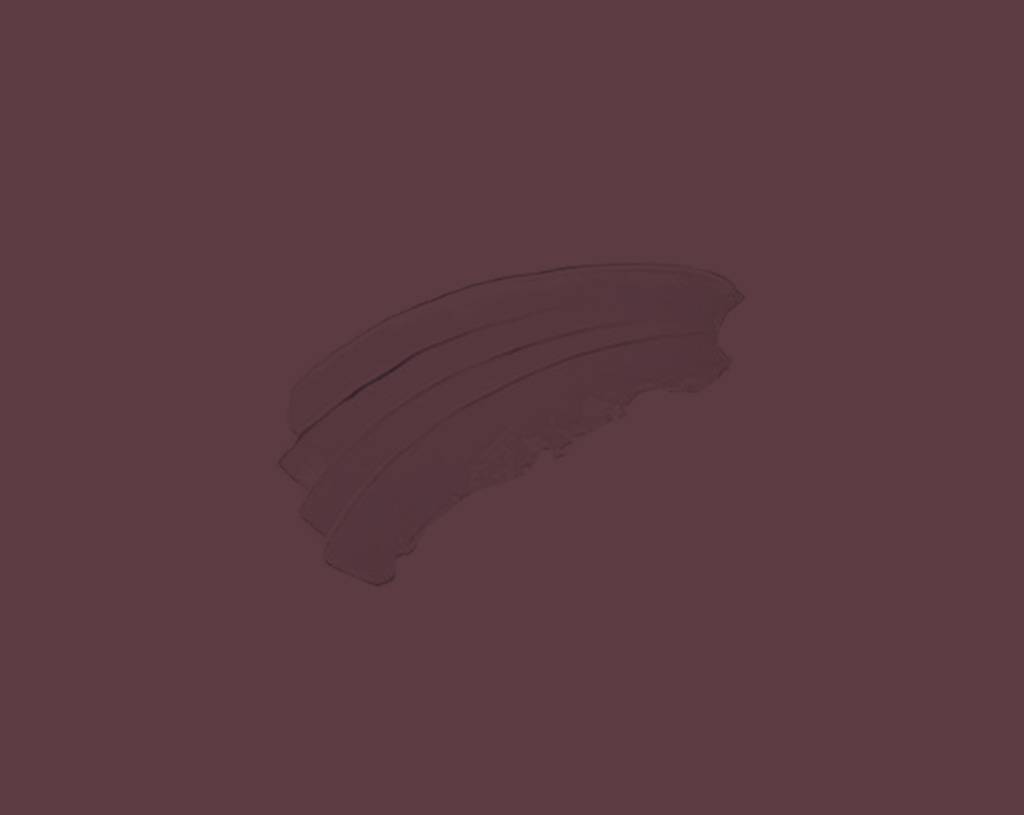 A swipe of dark maroon or plum-colored makeup product, such as lipstick or eyeshadow, is smeared on a solid matching maroon background.