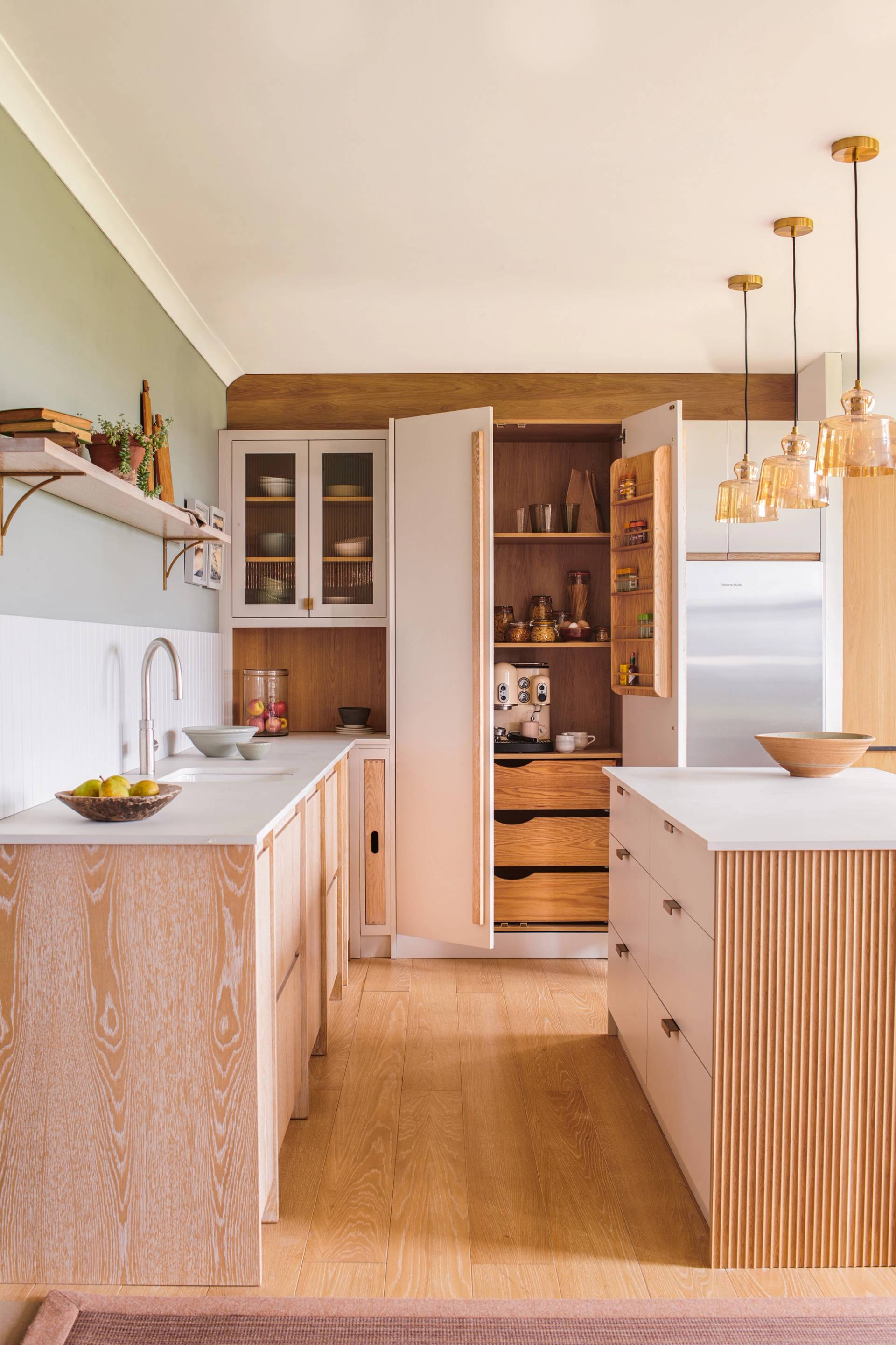 Texture and dimension are effortlessly achieved in this Glaven kitchen, with glazed units adding depth and character, and a panelled splashback providing a touch of visual interest, enhancing the kitchen's contemporary appeal.