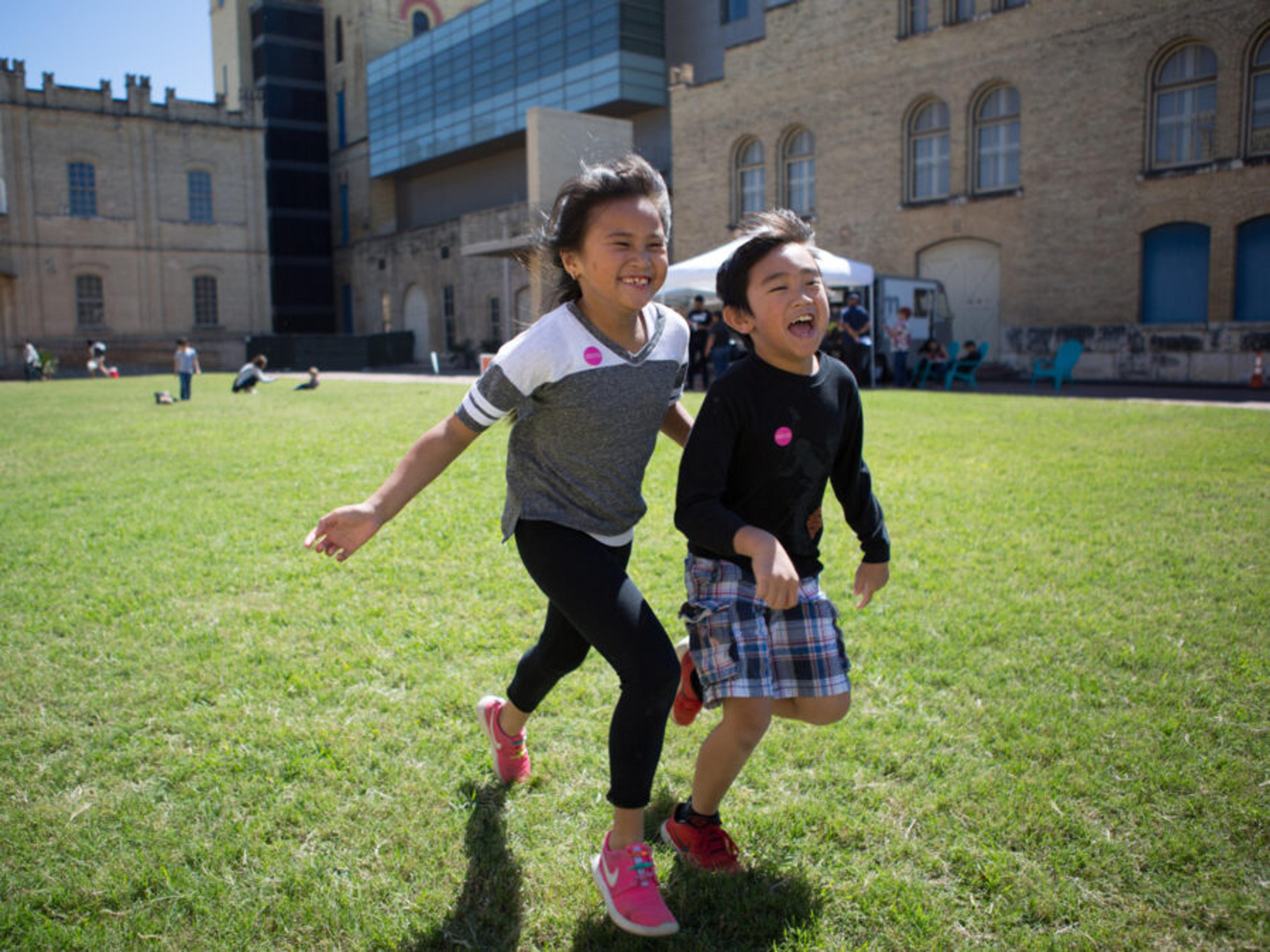 Children run on the lawn at the San Antonio Museum of Art