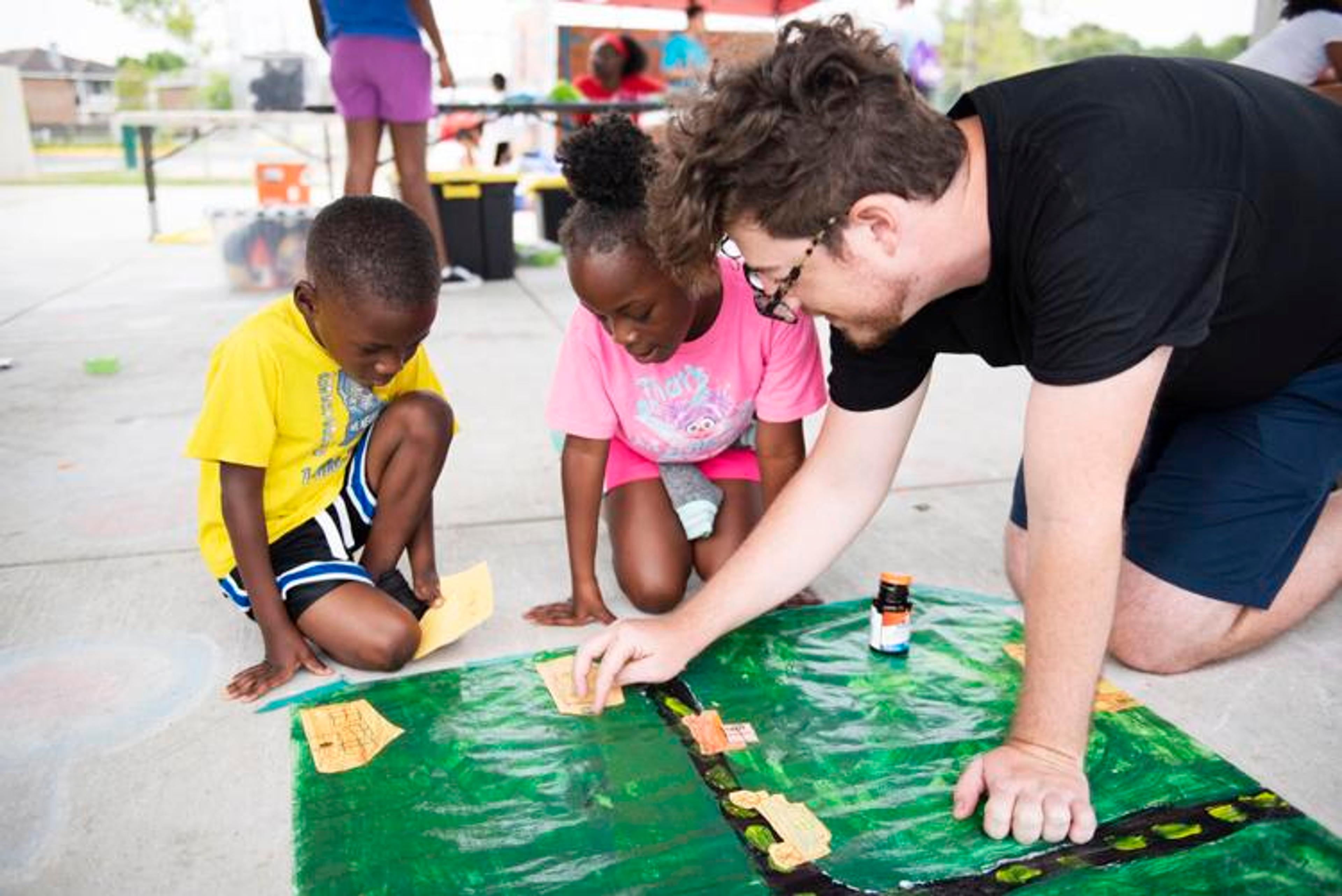 Grant Benoit, LSU Museum of Art educator and public programs manager, helps youngsters in the Neighborhood Arts Project, which will be held for free at various sites this summer.