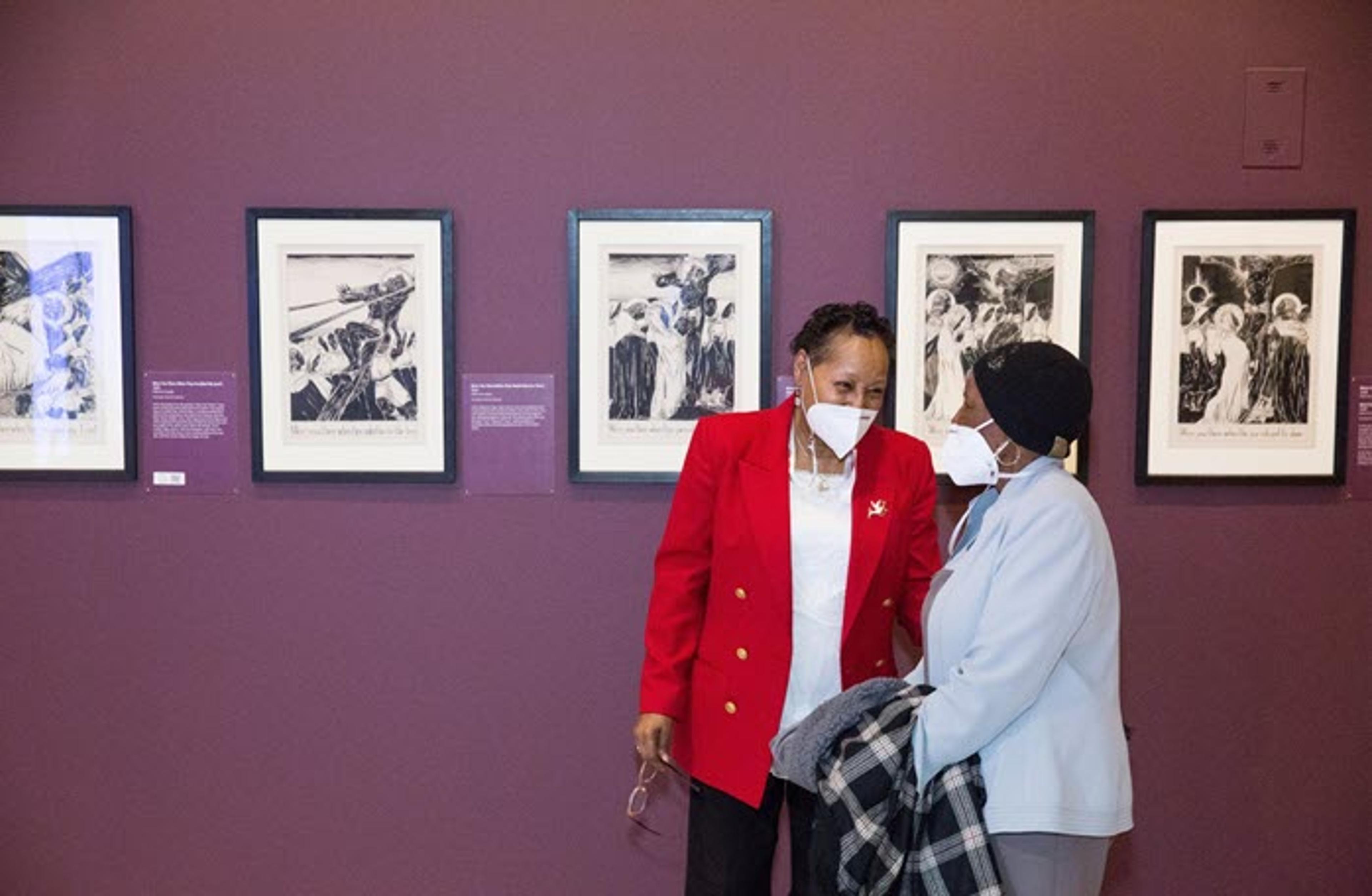 Two visitors gather in front of artworks in the exhibition. Photographed by Michael Foster Rothbart. Courtesy of the Munson Williams-Proctor Arts Institute, 2022