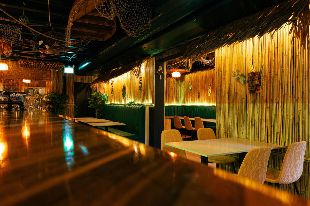 Bar-side seating framed by warm lighting and bamboo textures