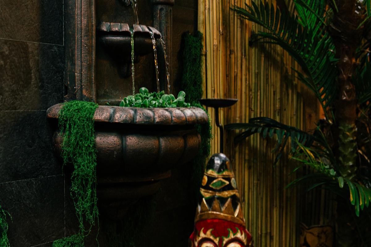 Lush tropical fountain and tiki decor inside Jungle Bird Tiki Lounge