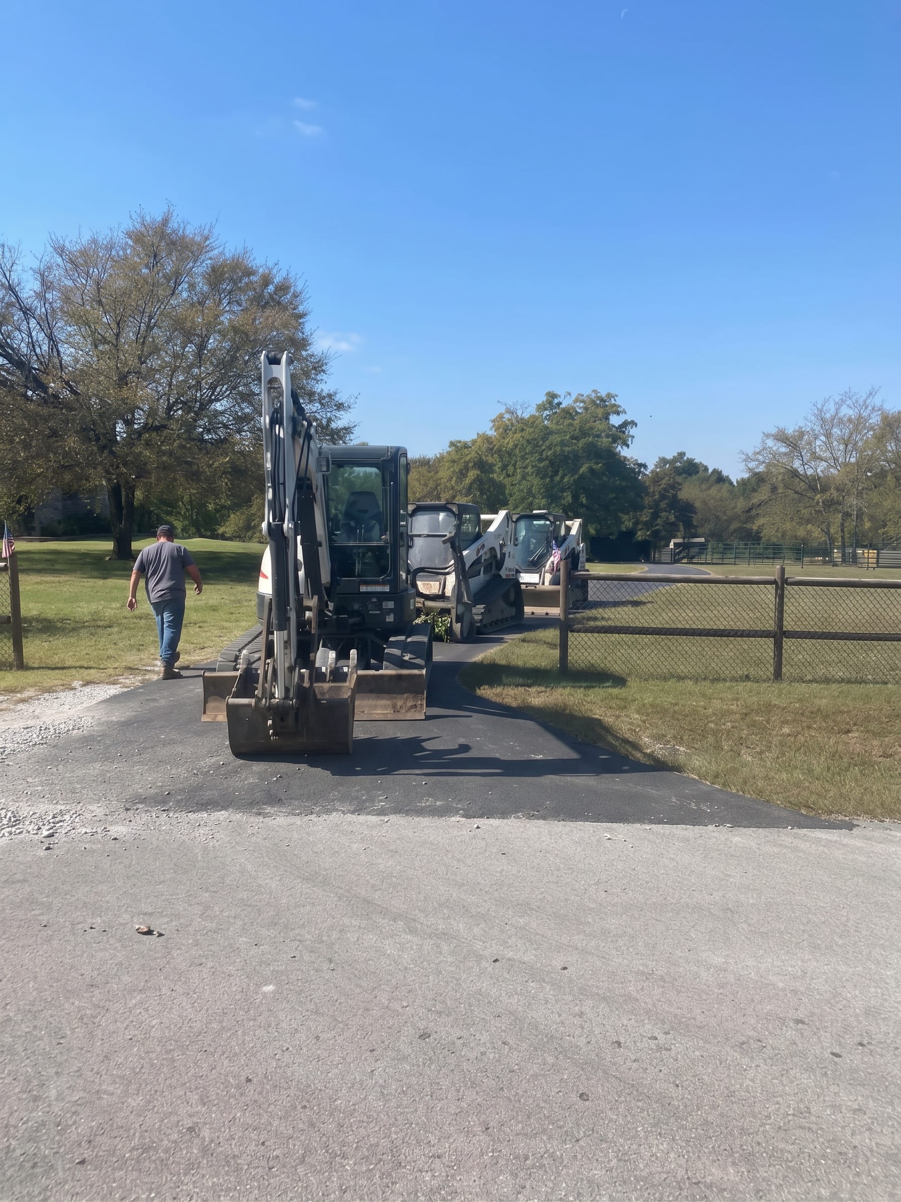 A mini excavator working a gravel driveway