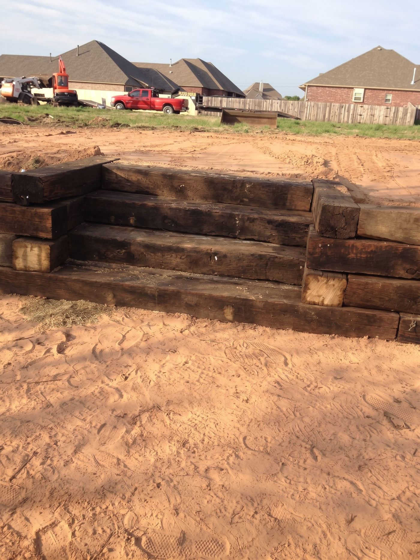 A timber retaining wall and steps in a graded yard