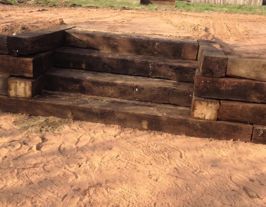 A timber retaining wall and steps in a graded yard