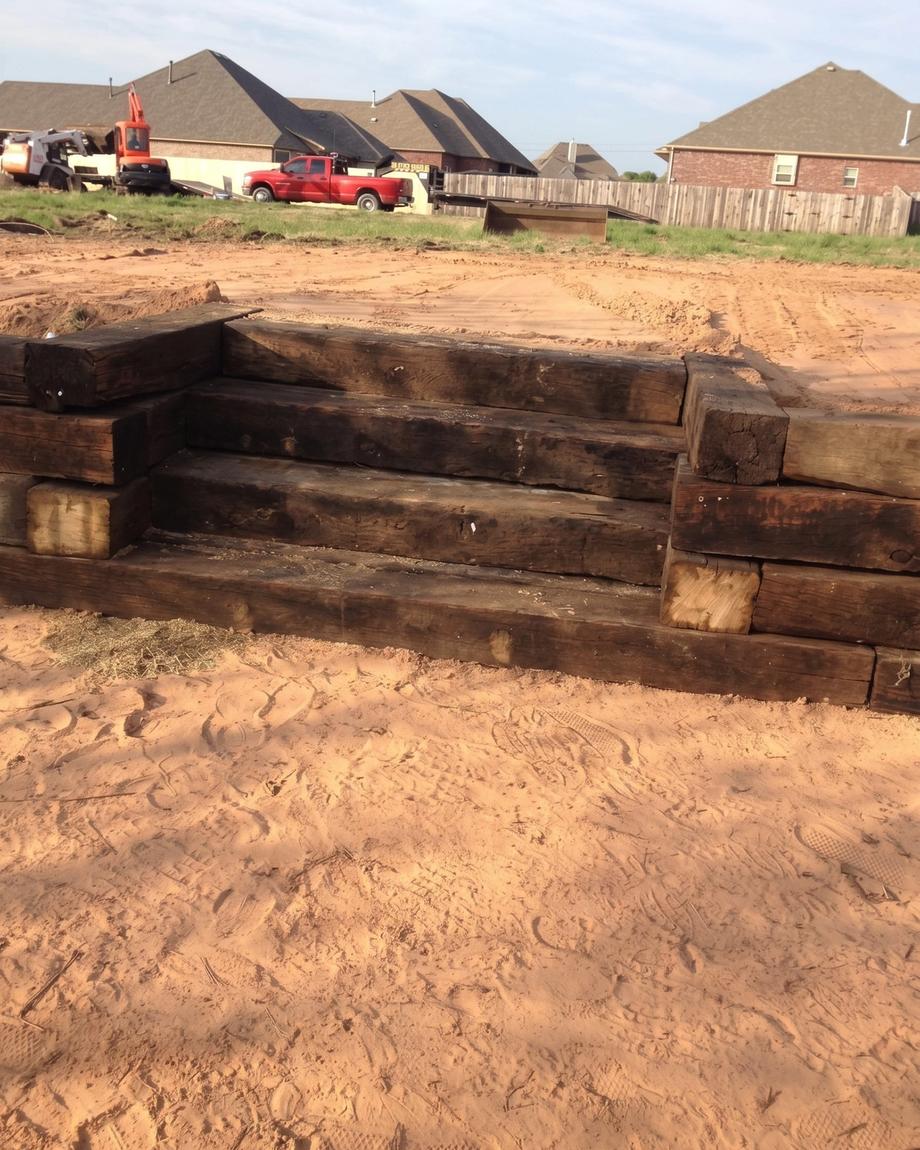 A timber retaining wall and steps in a graded yard