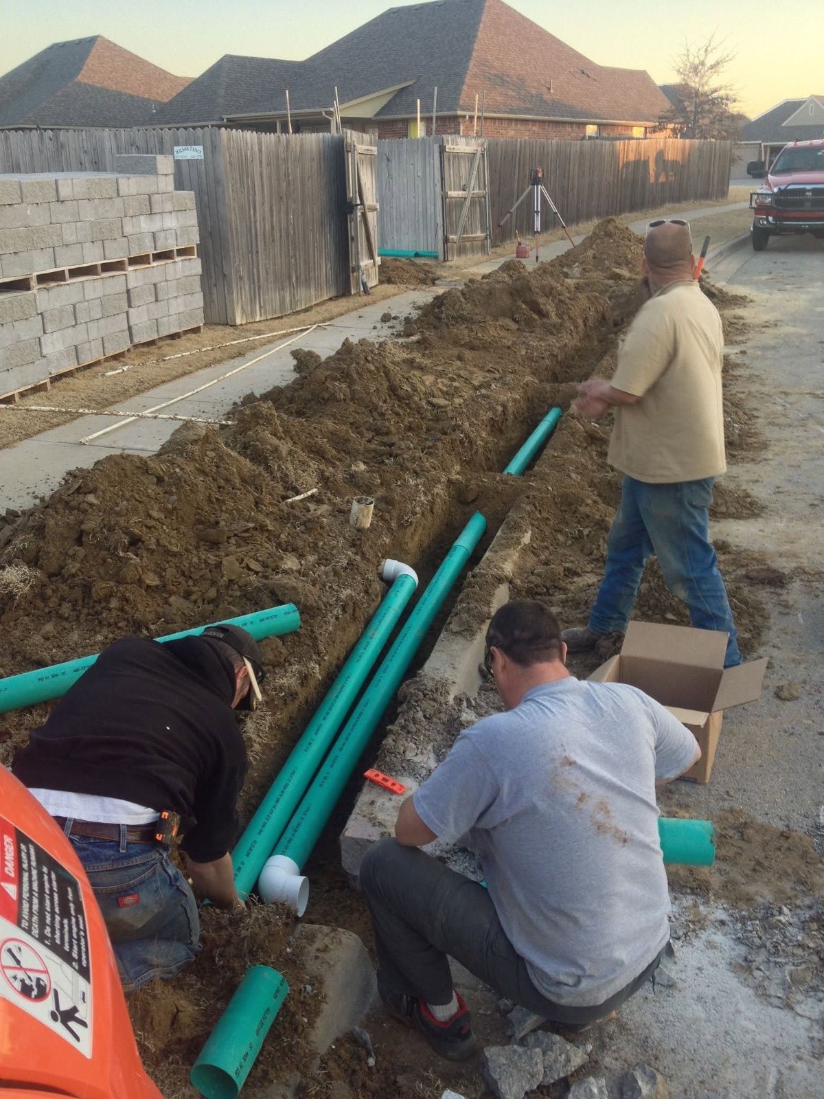 Laying drain pipe along a fence