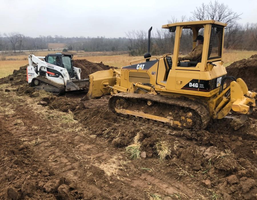 A CAT dozer and track loader clearing a site