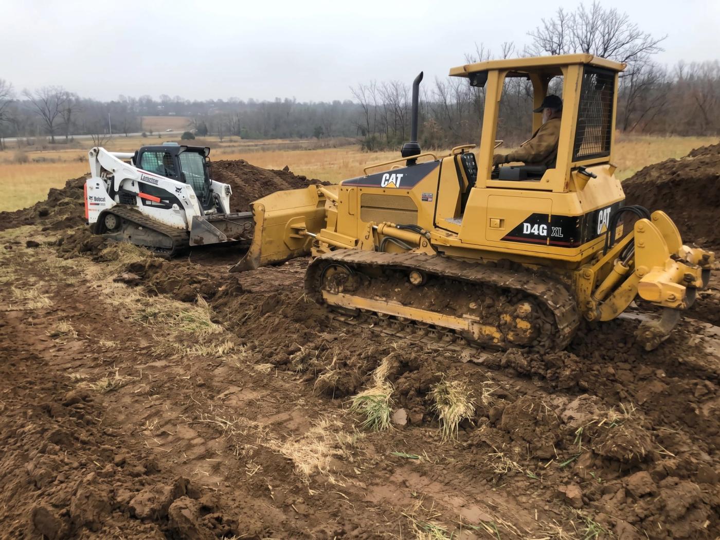 A CAT dozer and track loader clearing a site