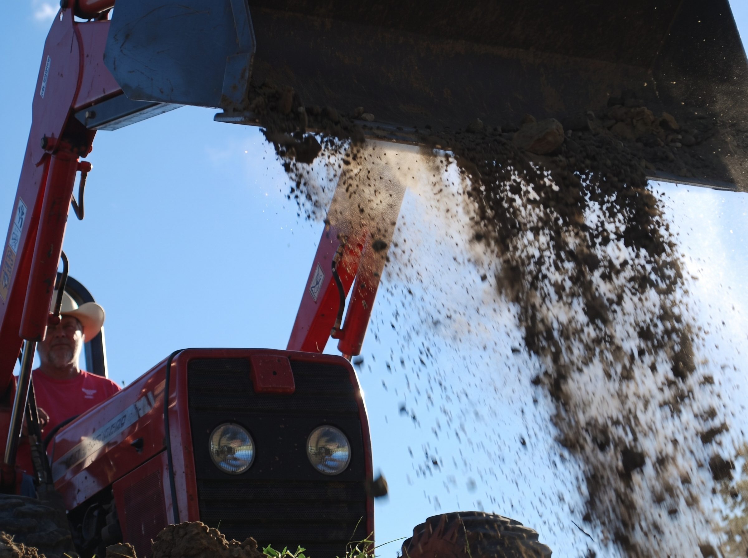 Loader bucket dumping dirt