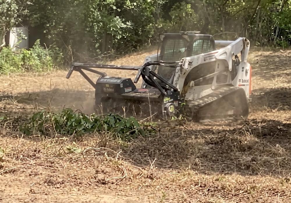 Tracked forestry mulcher grinding brush