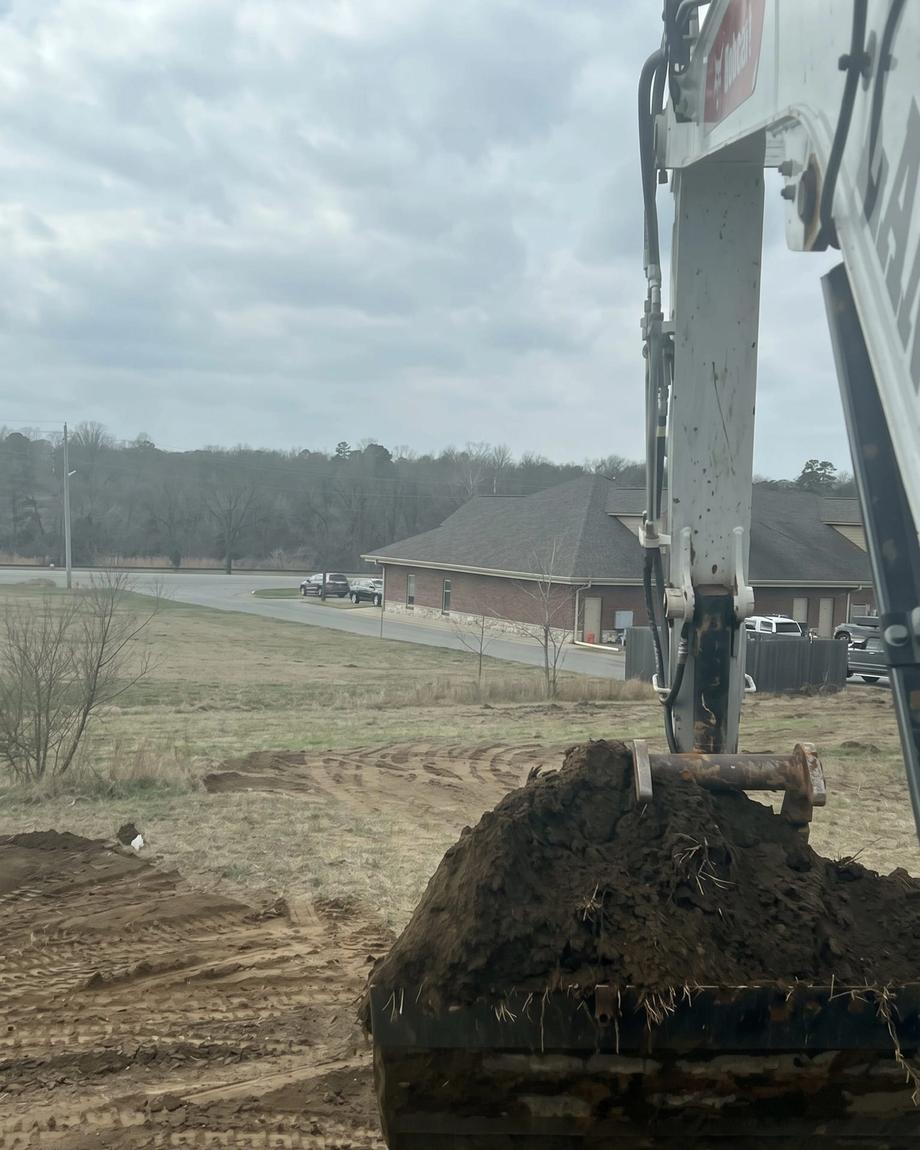 The excavator loading a red dump truck
