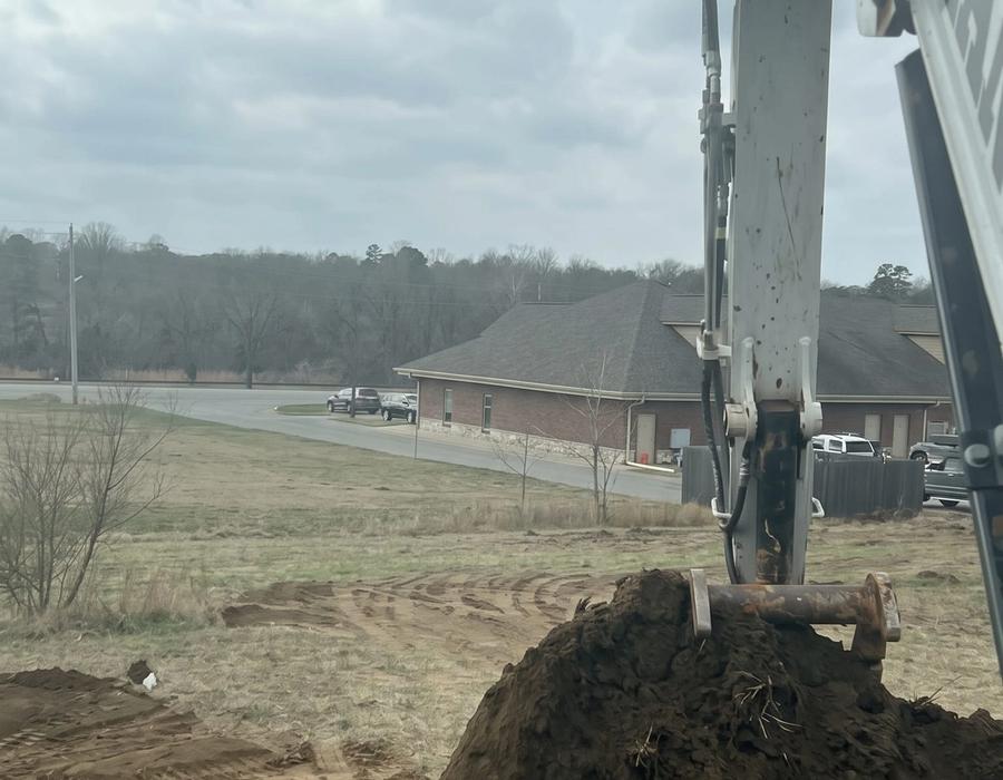 The excavator loading a red dump truck