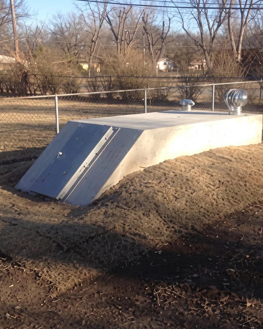 In-ground concrete storm shelter, freshly backfilled
