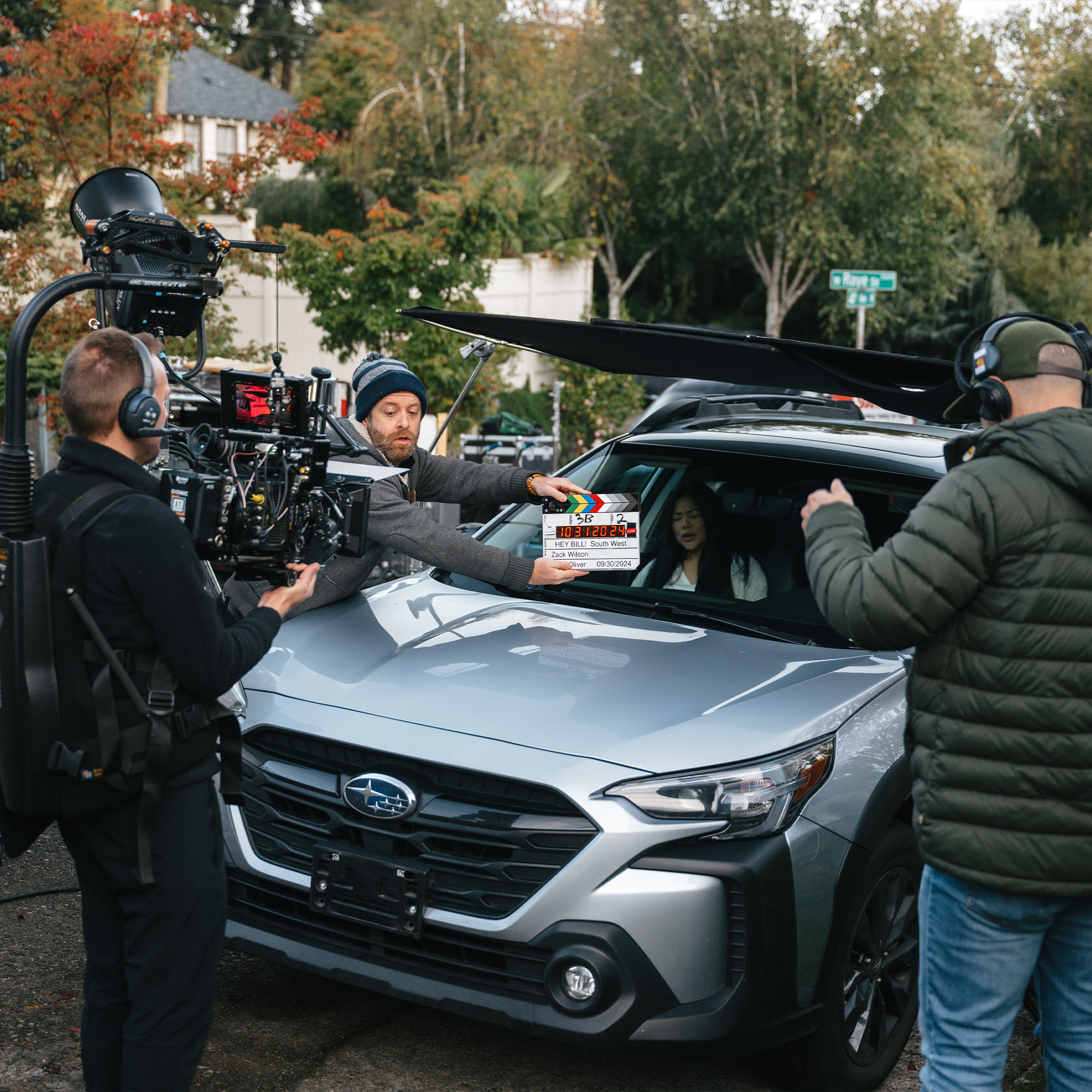 film crew shooting a scene with a car