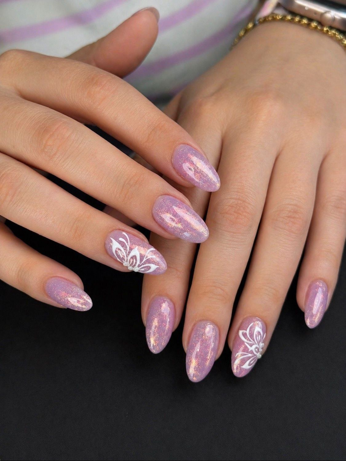 Fliederfarbenes Nageldesign mit weißen Detailzeichnungen