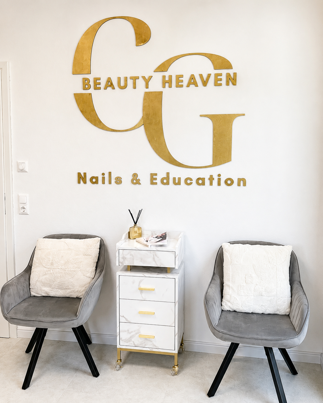Wartebereich mit goldenem CG Beauty Heaven Wandlogo