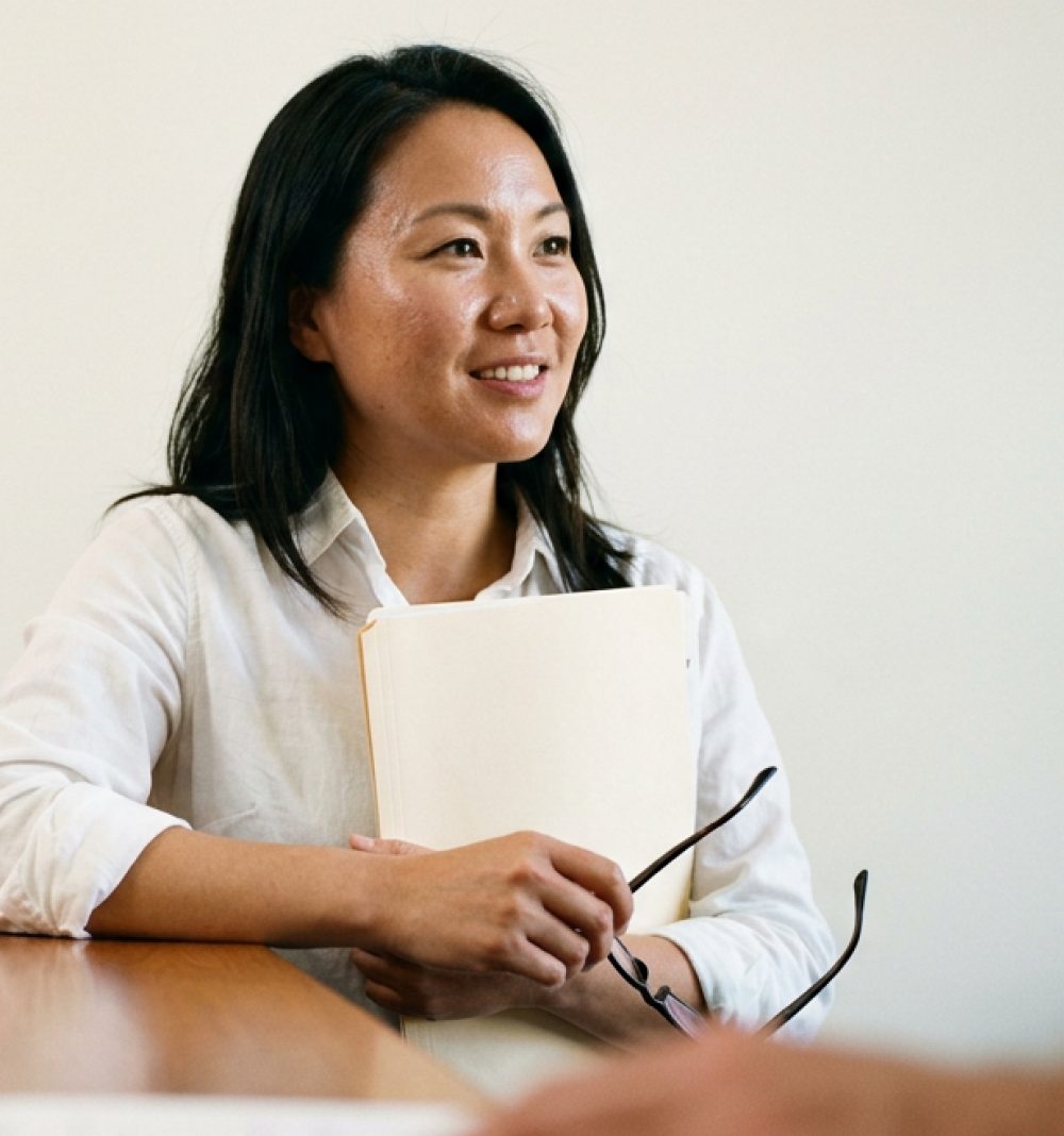 A clerk at a desk, holding a folder