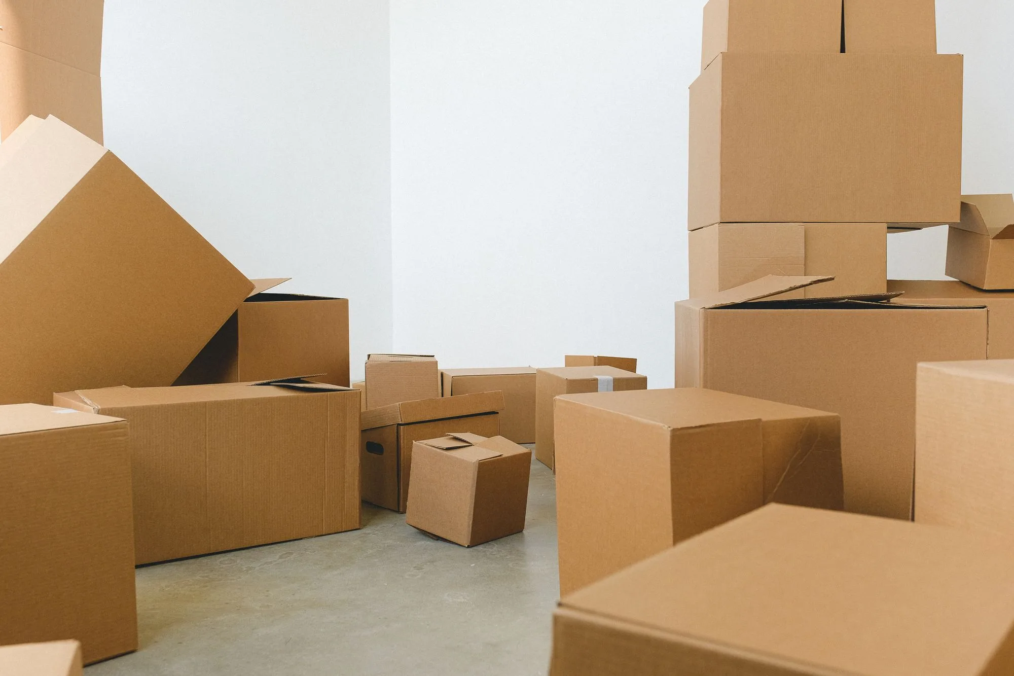 Kartonnen verhuisdozen in verschillende formaten in een lege kamer
