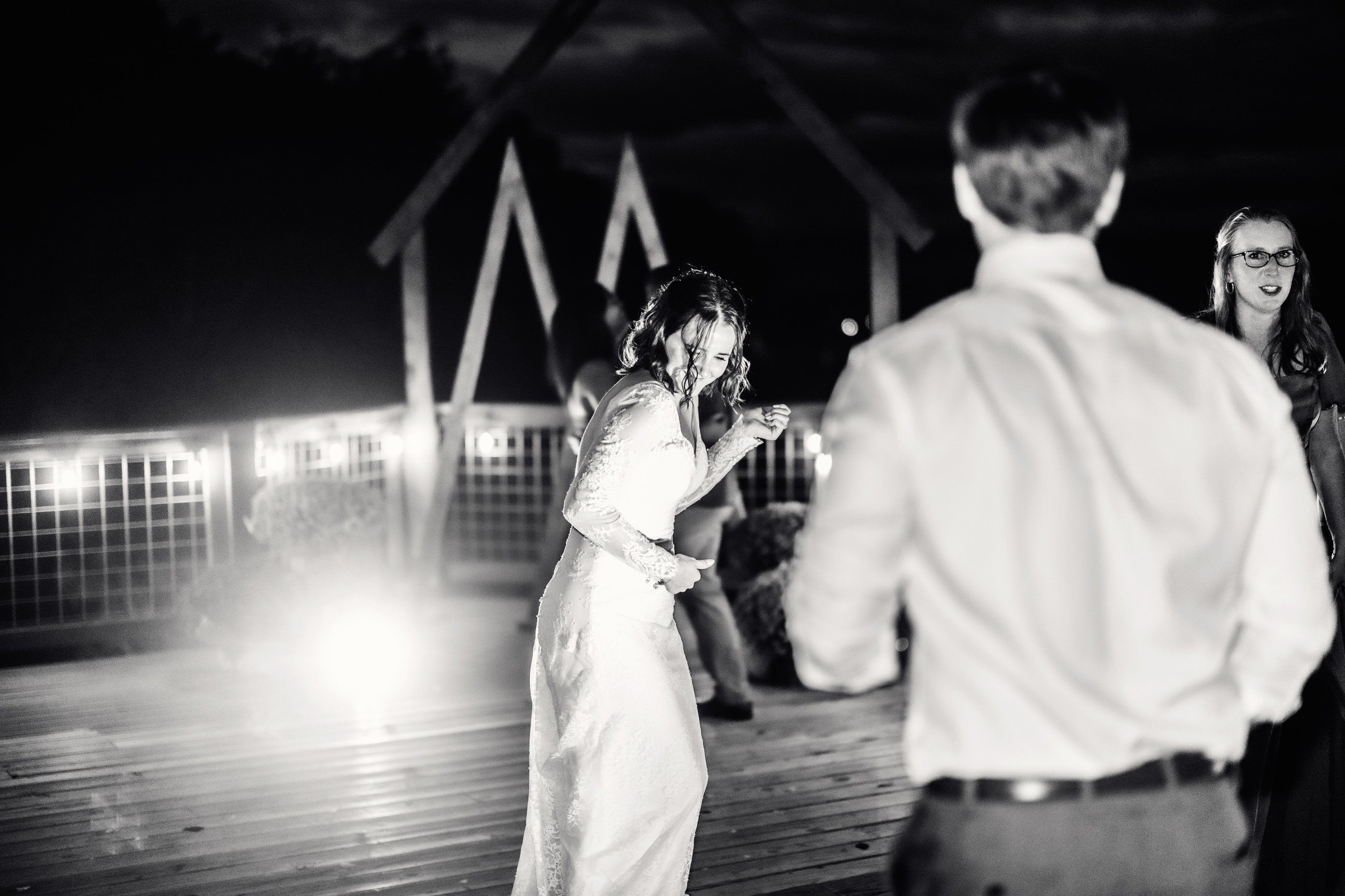 Black and white photo of a woman dancing on the venue deck.