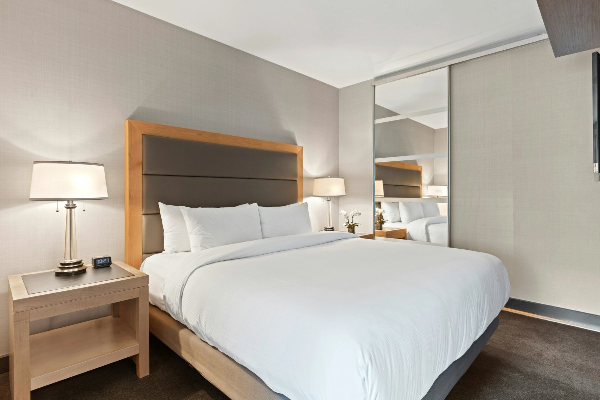 Hotel bedroom with gray walls and white bedding