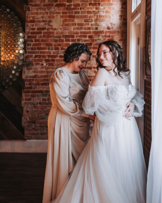 Bride and mother adjusting her dress pre-ceremony.